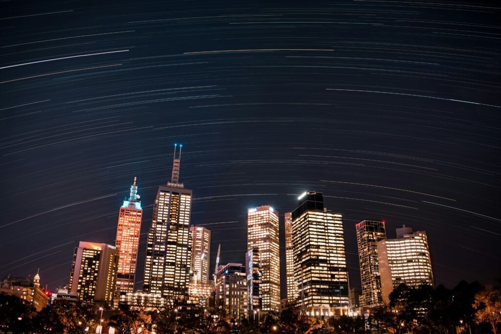 a city skyline at night with stars in the sky